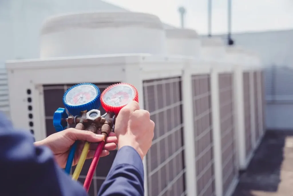 Technician checking air conditioning equipment with pressure gauges